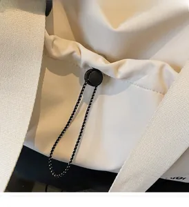 Detail des Kordelzugverschlusses mit verstellbarer Schnalle an weißer Reisetasche