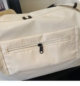 Makro-Detail von glattem Metallreißverschluss und strukturiertem Stoff am Reisetasche