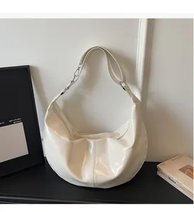 Detail of off-white glossy faux leather hobo bag with pleated texture and silver buckle