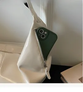 Detail of side zipper pocket on cream dumpling bag showing smartphone storage capacity