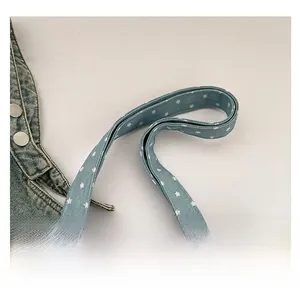 Detailed close-up of light blue fabric tote bag handles with white star patterns