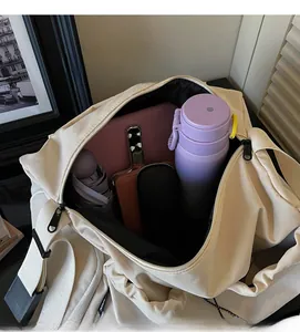 Draufsicht auf das Innere der beigen Reisetasche mit Tablet und Wasserflasche verstaut