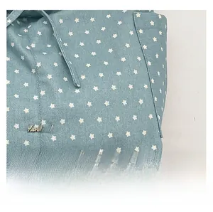 Detail showing blue star-patterned fabric and bronze 'Handmade' metal logo plate