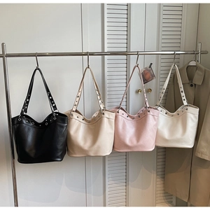 Detail view of large tote bags with silver eyelets in black, beige, pink and white