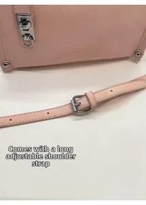 Detail of light pink leather bag featuring adjustable shoulder strap and silver buckle