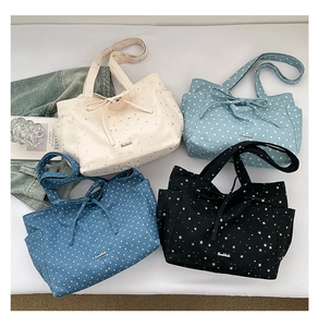 Detailed view of canvas tote bags with star patterns, bow accents, and side pockets