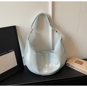 Detail view of mint green hobo bag featuring glossy patent leather and side zipper