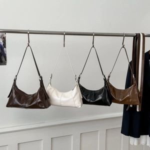 Detailed close-up showing four vintage crescent bags in brown, cream, black and tan colors