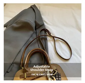 Détail de la bandoulière réglable et du cuir texturé de ce sac à main marron chic