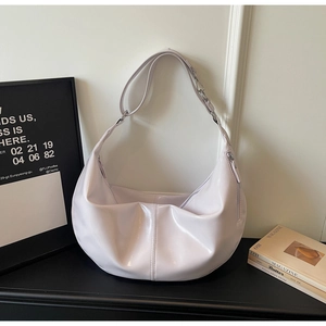 Detail of lavender glossy patent leather hobo bag with silver chain and vertical stitching