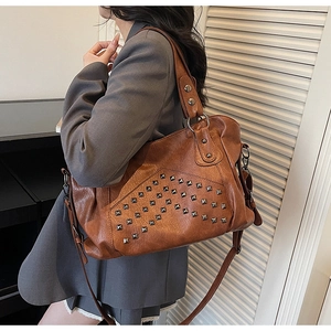 Brown tote bag with retro silver rivets and textured leather on a model's shoulder