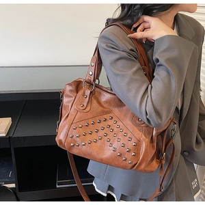 Detail shot of brown faux leather tote bag with silver square rivets and detachable strap