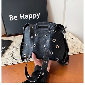 Dettaglio della borsa in pelle litchi nera con occhielli metallici argentati