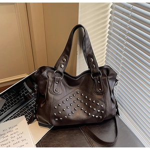 Close-up of silver square rivets and vintage PU leather texture on a dark brown tote bag