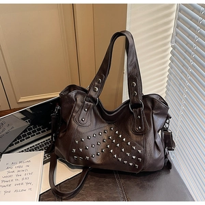 Detail of vintage coffee brown tote bag with square silver rivets and matte leather texture