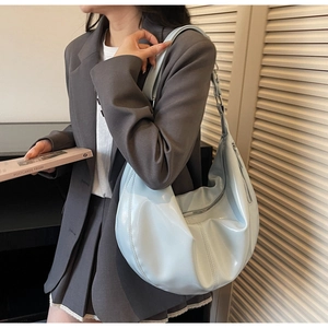 Detail of baby blue hobo bag with smooth glossy finish and wide shoulder strap