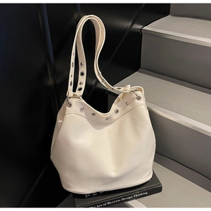 Detailed shot of cream white Hobo bag with wide strap and silver metal eyelets accents
