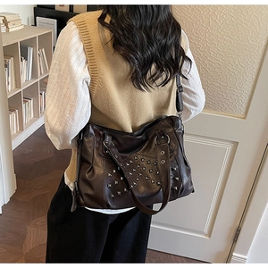 Detail view of large dark brown tote bag with vintage studs and high-quality synthetic leather