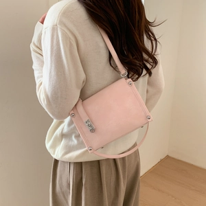 Detailed back view of a light pink leather crossbody pillow bag with silver turn-lock clasp