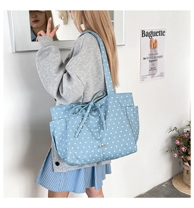 Detail of light blue star pattern tote bag with decorative bow and side storage pocket