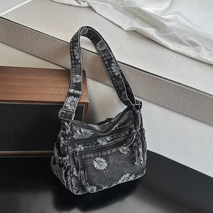 Detail showing vintage dark grey denim crossbody bag with daisy prints and zipper pockets