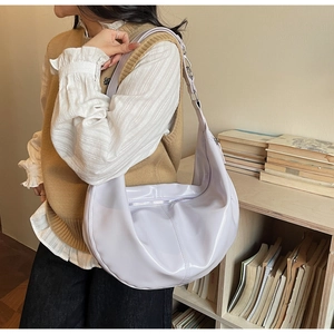 Detailed view of lavender PU leather hobo bag worn by a model in a cozy indoor setting