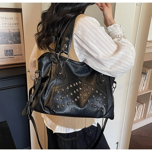 Detail view of the black retro leather tote featuring silver rivets and metal ring hardware
