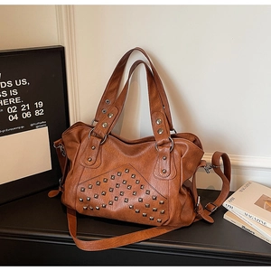 Detailed macro view of vintage brown rivet tote bag with PU leather and metal ring accents