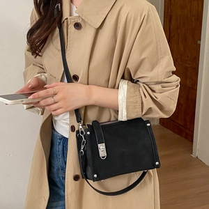 Minimalist black retro pillow bag with silver buckle and crossbody strap on a model
