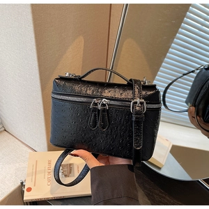 Detail of black ostrich embossed leather mini box bag with silver hardware and top handle