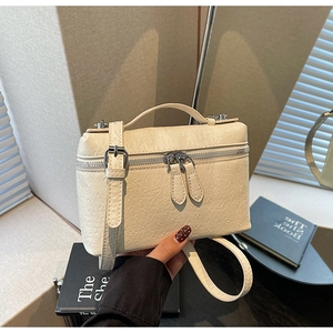 Close-up of beige ostrich texture synthetic leather on a stylish square handbag