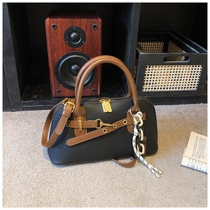 Détail du sac bowling rétro en cuir avec mors doré et pendentif en corde tressée
