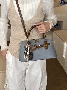 Sac bowling en denim bleu avec lanières en cuir marron et breloques métalliques vintage