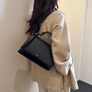 Vue détaillée du sac à main en cuir noir à motif litchi montrant son profil élégant