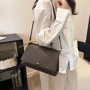 Vue détaillée du sac à bandoulière en cuir grainé marron foncé avec boucle dorée
