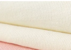 Makrodetail aus weichem Rippstrick-Baumwollstoff mit zartem Volantsaum und rosa Akzenten
