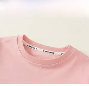 Detail des rosa Baumwoll-T-Shirt-Ausschnitts mit Rippstrick und Markennackenband