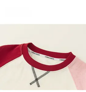 Detail of child raglan tee showing crew neck with interior reinforcement tape and stitching