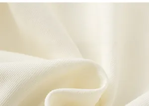 Gros plan sur la texture du tricot en coton blanc doux avec détails en maille côtelée