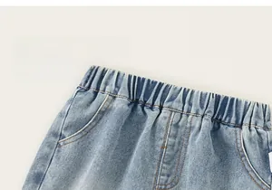 Detail of boys' light blue denim shorts with elastic waist and loose fit soft fabric