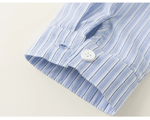 Detailaufnahme einer blau-weiß gestreiften Hemdmanschette mit weißem Knopf