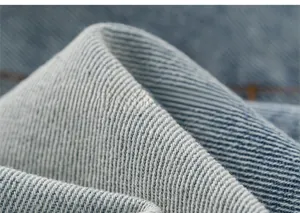 Detailed close-up showing light blue denim fabric texture and diagonal twill weave