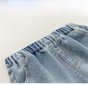 Detail of blue denim shorts showing elastic waistband with contrast stitching