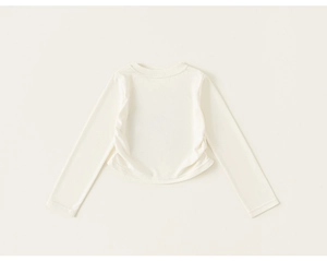 Détail d'un haut à manches longues beige avec fronces latérales pour petites filles