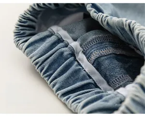 Close-up of elastic waistband on light blue denim shorts with professional stitching