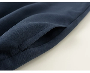 Detailaufnahme der Seitentasche und Köpergewebe-Textur einer dunkelblauen Schuluniform