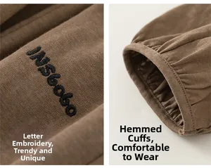 Détail du pantalon jogging marron enfant avec broderie de lettres et poignets