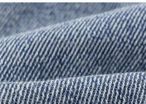 Macro shot of high-quality blue denim fabric showing twill weave pattern and soft texture
