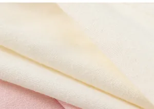 Detailaufnahme von weichem rosa und cremeweißem Strickstoff für Kinder T-Shirts aus Baumwolle