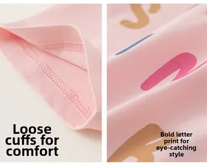 Detail eines rosa Kinder-T-Shirts mit lockeren Ärmeln und buntem Buchstabendruck